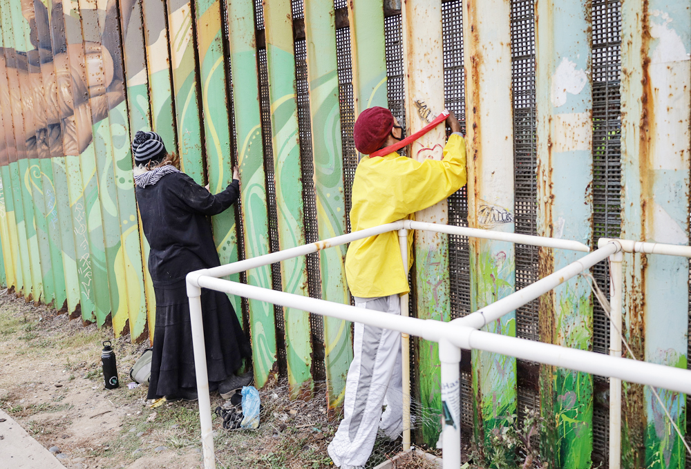 Activistas se encadenan al muro fronterizo en Tijuana en protesta por su remodelación